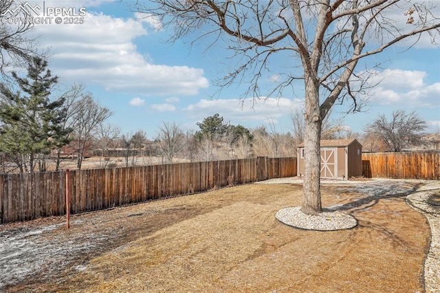 view of yard featuring a shed, a fenced backyard, and an outdoor structure