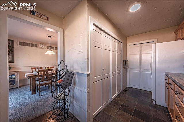 corridor featuring stone finish flooring and visible vents