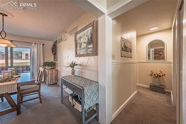 hallway featuring carpet floors and a wainscoted wall