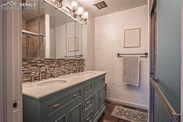 bathroom with double vanity, tasteful backsplash, a sink, and baseboards