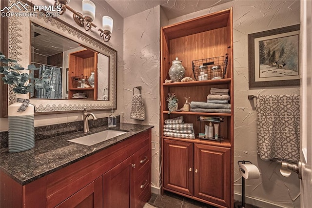 bathroom featuring a textured wall and vanity