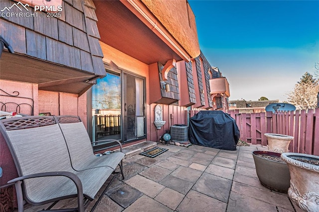 view of patio featuring a grill and fence