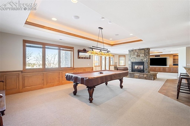 game room featuring carpet floors, a wealth of natural light, a raised ceiling, and wainscoting