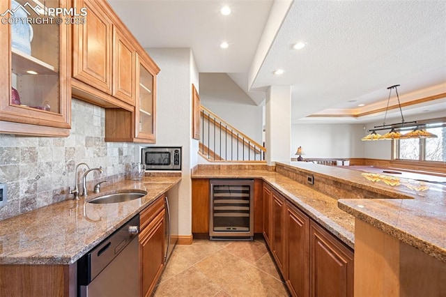 kitchen featuring a raised ceiling, dishwashing machine, wine cooler, stainless steel microwave, and a sink