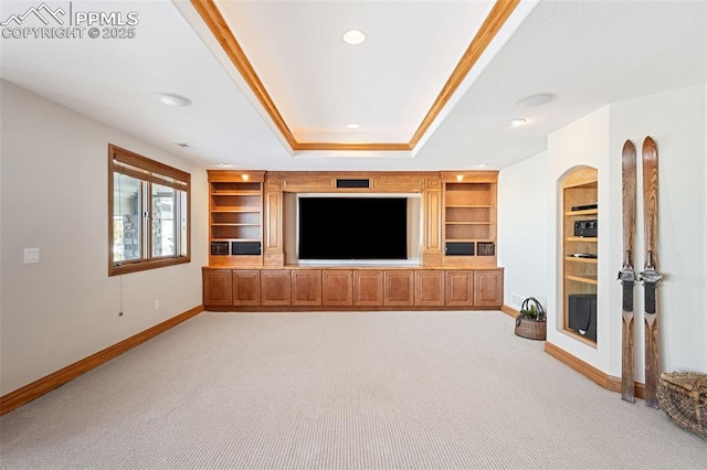 unfurnished living room with built in features, a raised ceiling, light carpet, and baseboards