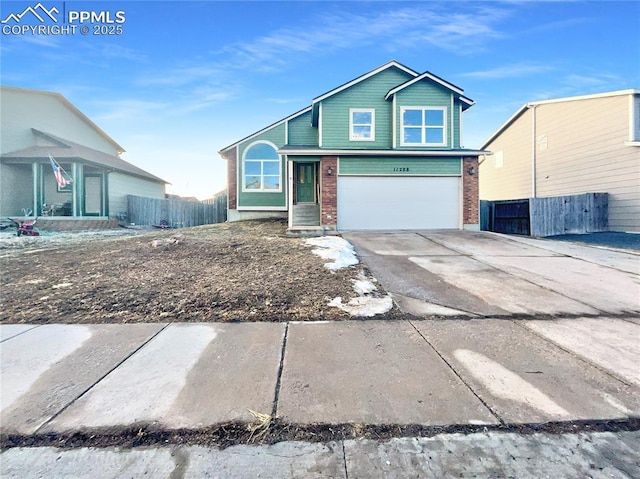 view of front of property featuring driveway, an attached garage, fence, and brick siding