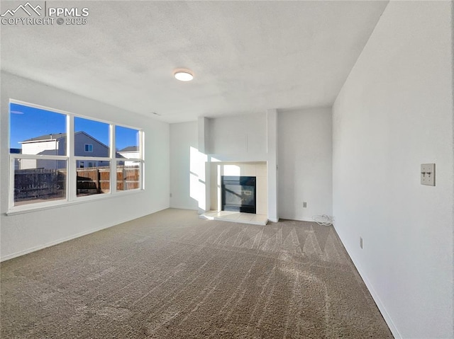 unfurnished living room with carpet floors and a fireplace