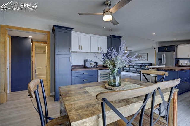 kitchen featuring light wood-style flooring, stainless steel refrigerator with ice dispenser, wood counters, and a ceiling fan