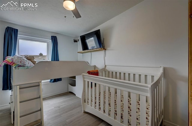 bedroom featuring ceiling fan, a textured ceiling, and wood finished floors