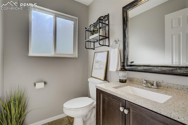 bathroom with toilet, tile patterned flooring, baseboards, and vanity