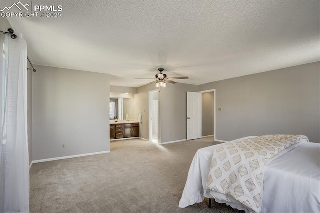 carpeted bedroom featuring ceiling fan, ensuite bath, baseboards, and a textured ceiling