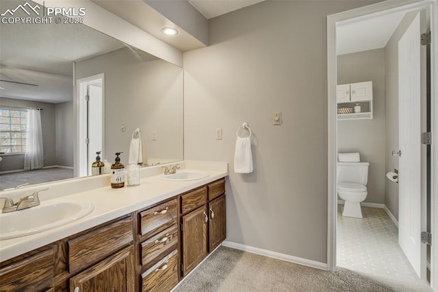 bathroom with toilet, baseboards, and a sink