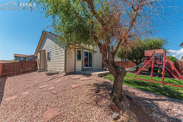 exterior space with a fenced backyard, a front lawn, and a playground