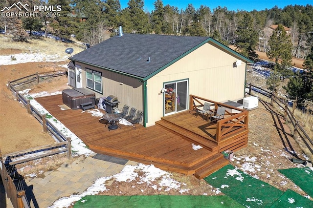 exterior space featuring a shingled roof, fence, and a wooden deck