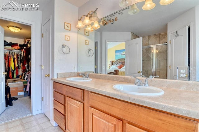 ensuite bathroom with double vanity, a stall shower, a sink, and tile patterned floors