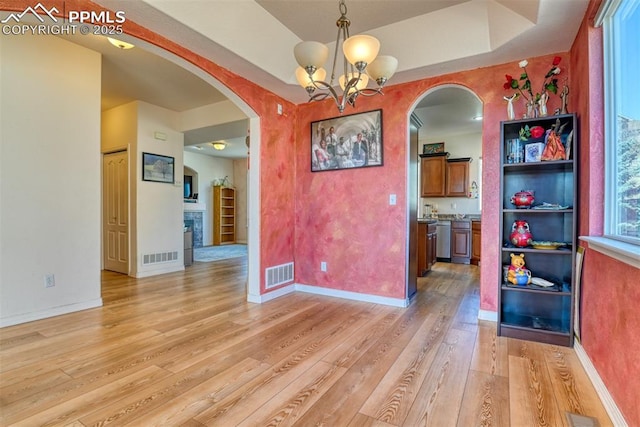 unfurnished dining area featuring light wood-style flooring, visible vents, and baseboards