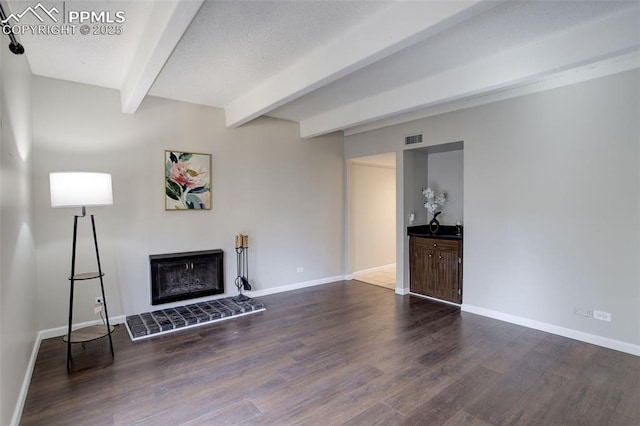 9995 E Harvard Ave Unit 155, Denver, CO 80231 - unfurnished living room with visible vents, dark wood-style flooring, beamed ceiling, and a glass covered fireplace