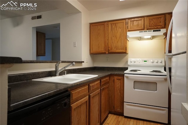 kitchen featuring white appliances, visible vents, brown cabinets, under cabinet range hood, and a sink