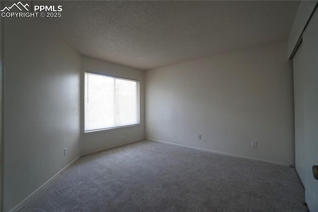 unfurnished room with baseboards, a textured ceiling, and carpet flooring