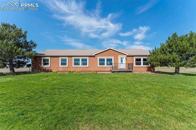 view of front of property featuring a front lawn and stucco siding