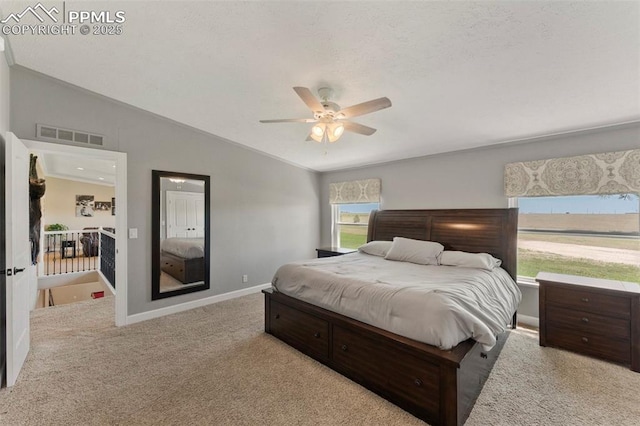 bedroom featuring carpet floors, lofted ceiling, visible vents, a ceiling fan, and baseboards