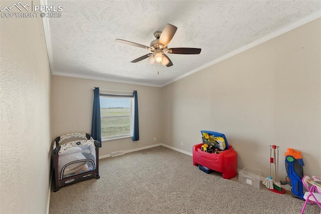 interior space with a textured ceiling, ceiling fan, baseboards, carpet, and crown molding