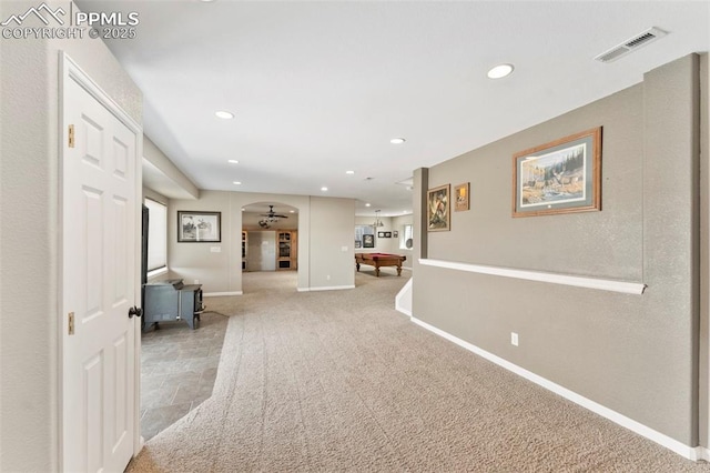 hallway with visible vents, arched walkways, baseboards, carpet, and recessed lighting