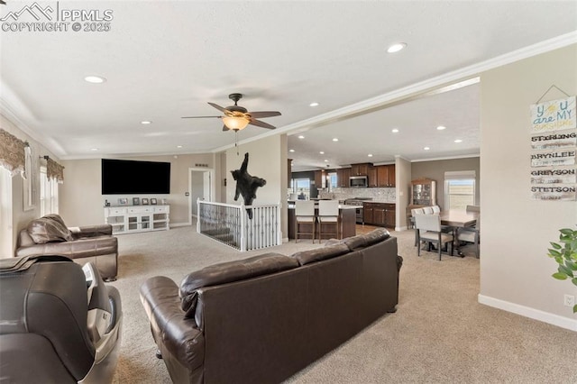 living area with light carpet, baseboards, crown molding, and recessed lighting