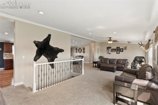 living area featuring light carpet, baseboards, and crown molding