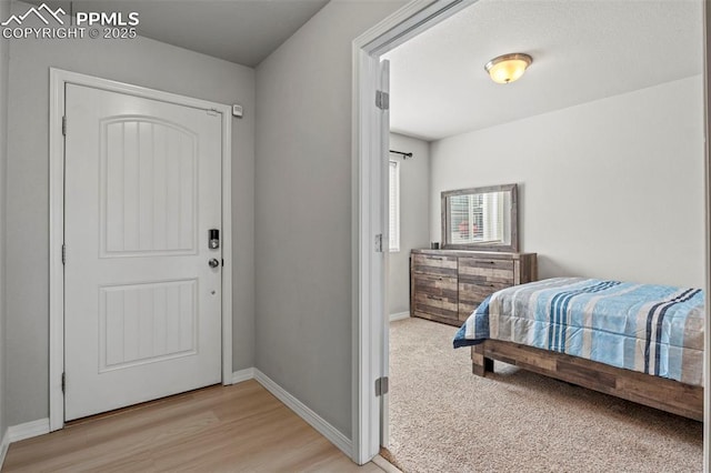 bedroom with light wood finished floors and baseboards