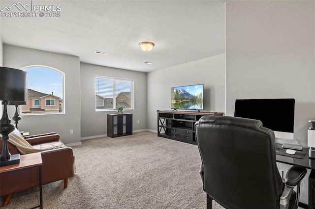 carpeted office space featuring baseboards, visible vents, and a textured ceiling