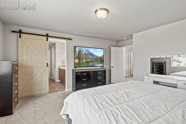 bedroom featuring carpet, a barn door, multiple windows, and ensuite bathroom