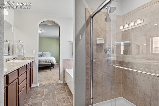 ensuite bathroom featuring a bath, ensuite bath, a shower stall, and vanity