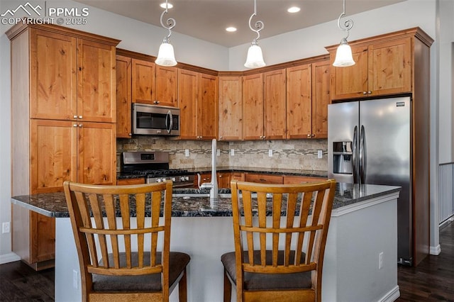 kitchen with stainless steel appliances, dark wood-style flooring, backsplash, and decorative light fixtures