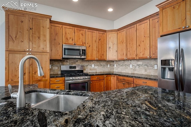 kitchen with stainless steel appliances, backsplash, a sink, and brown cabinets