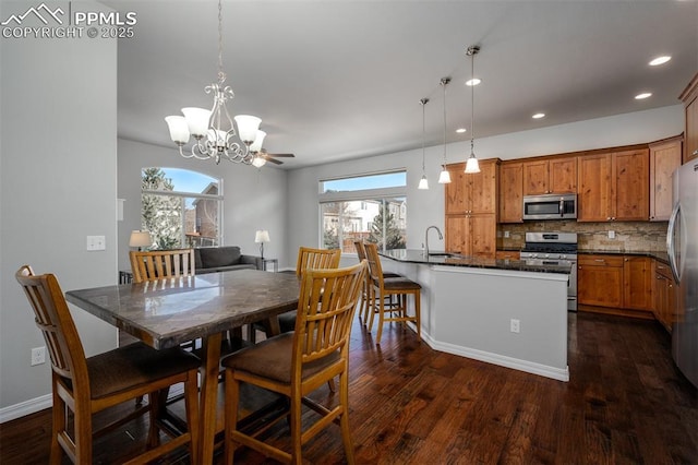 dining area featuring dark wood-style floors, recessed lighting, a healthy amount of sunlight, and an inviting chandelier