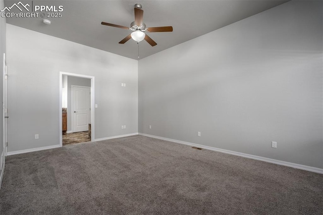 empty room with carpet, a ceiling fan, and baseboards