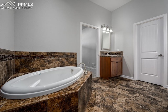 bathroom with a garden tub and vanity