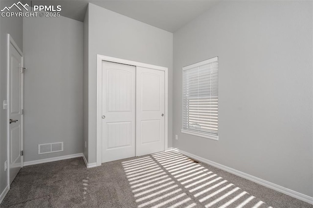 unfurnished bedroom featuring a closet, carpet flooring, visible vents, and baseboards