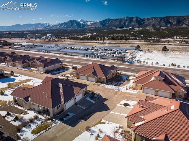 snowy aerial view with a residential view and a mountain view