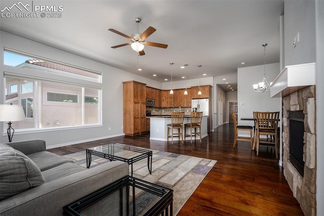 living room featuring recessed lighting, dark wood finished floors, a wealth of natural light, and ceiling fan with notable chandelier