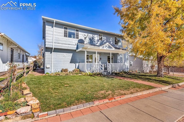 view of front of property featuring a balcony, fence, a porch, and a front yard