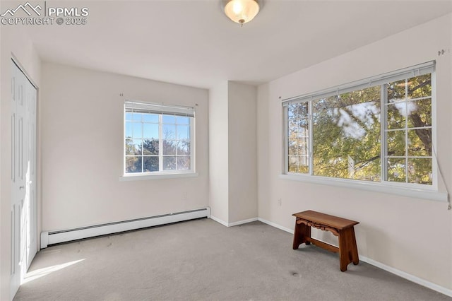 unfurnished bedroom with carpet floors, multiple windows, a baseboard radiator, and baseboards