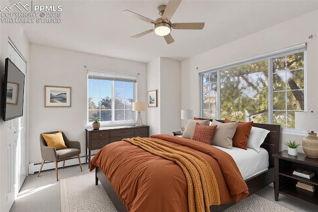 bedroom with a baseboard heating unit, ceiling fan, and carpet flooring