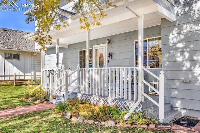 view of exterior entry featuring covered porch