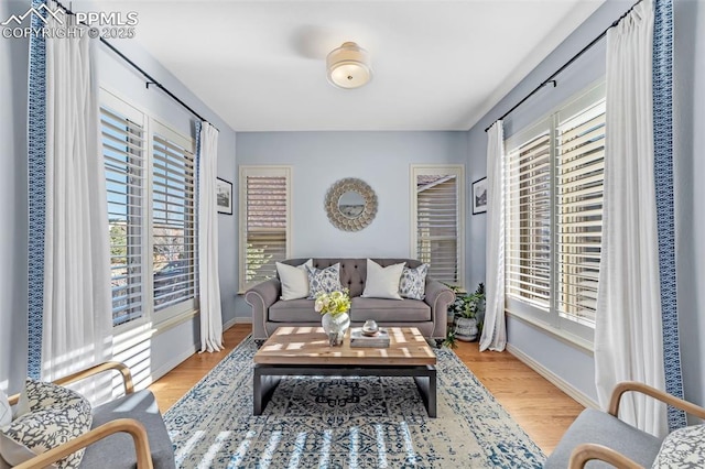 sitting room with baseboards and light wood-style floors