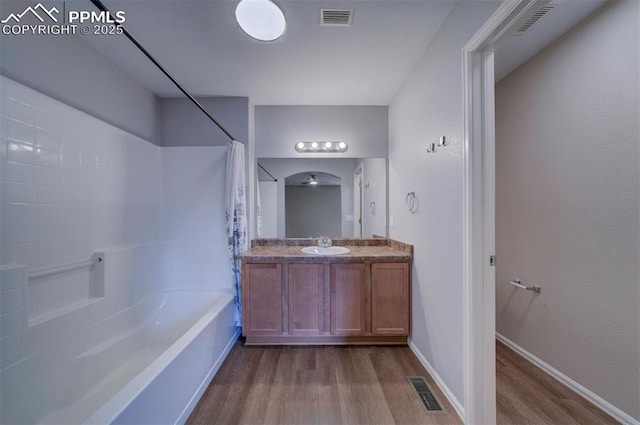 full bathroom with visible vents, shower / tub combo with curtain, vanity, and wood finished floors