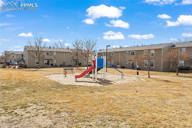 communal playground featuring a residential view and a yard