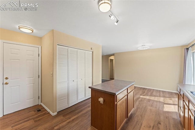 kitchen featuring a kitchen island, baseboards, and wood finished floors