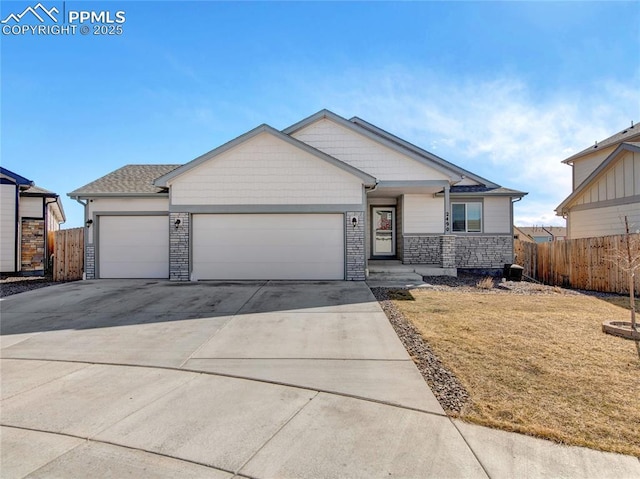 view of front facade featuring concrete driveway, an attached garage, a front yard, fence, and stone siding